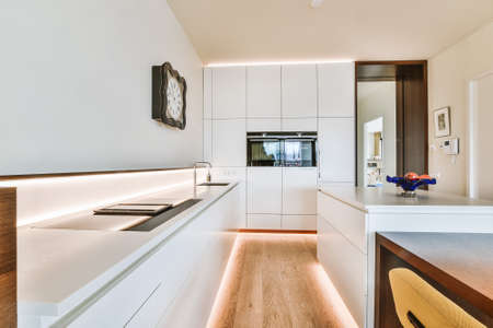 Contemporary home interior design of modern light apartment with open space kitchen with minimalist style white furniture and dining zoneの写真素材