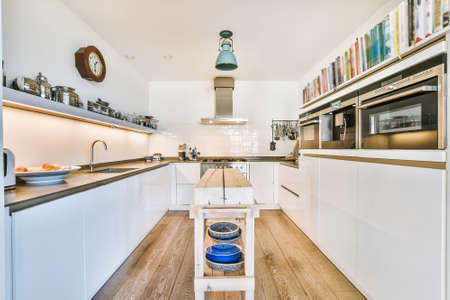 Modern galley kitchen with wooden cabinets and minimalist design in studio attic apartment with...