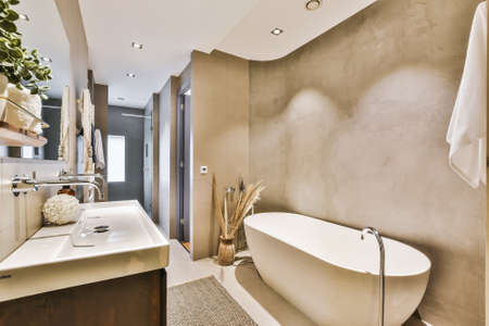 Beautiful bathroom with a big mirror and marable wallsの写真素材