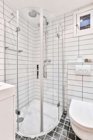 Shiny faucets installed on ceramic sink under mirror in modern bathroom at home