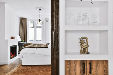 Stylish shelf with a figurine of a monkey next to the door to the bedroom