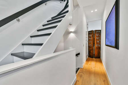 Designed in a minimalistic style staircase hall. Interior of luxury house stairs