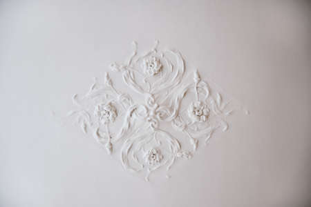 Cozy white pattern with flowers on the wallの写真素材
