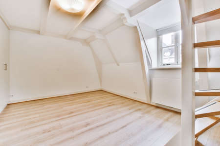 Large room interior with small window and staircase