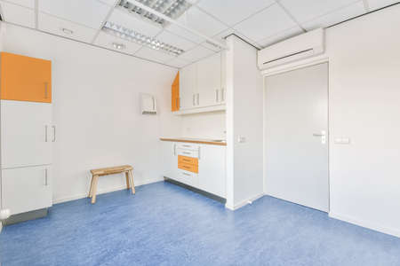 A bright room with a white cabinet with orange shelves