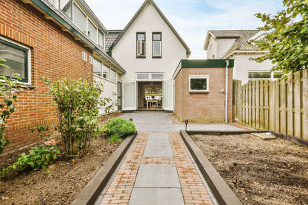 The backyard of the house with a garden and trees