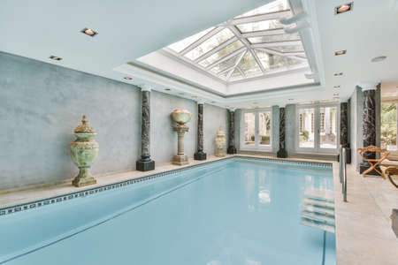 Large beautiful indoor swimming pool with glass ceiling