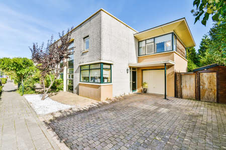 View of a two-storey pretty house with a fence of greeneryの写真素材