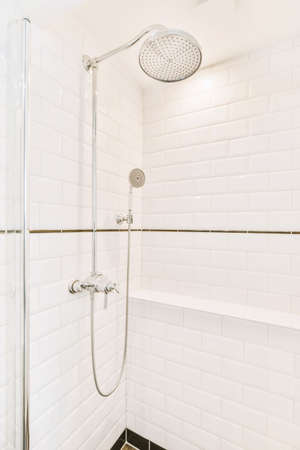 Contemporary bathroom with bathtub and glass shower cabin with light light tile and white ceilingの写真素材