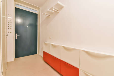 Black front door to an apartment with shelves on the walls