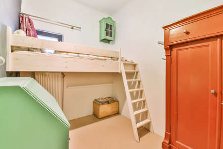 Small bedroom with ceiling bed with staircase