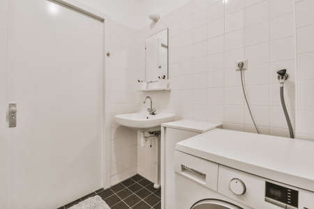 Cozy bright bathroom with a modern washing machineの写真素材