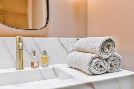 Luxurious washroom with peach walls and marble top and sinkの写真素材