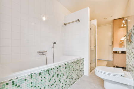 Stylish interior design of small bathroom with white walls and shelves and with large mirror near...