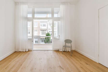 Cozy room with a single chair and doors to the balconyの写真素材