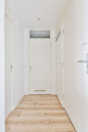 Attractive bright corridor with doors and an iron hanger on the wallの写真素材