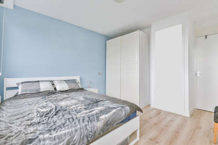 Attractive bedroom with plain gray bedspread on the bed