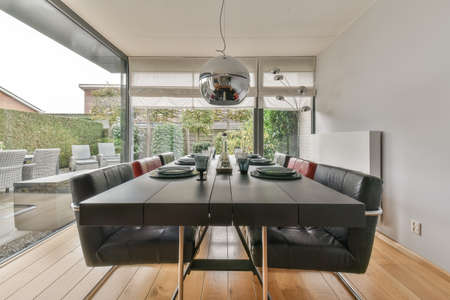 Interior of light room with stylish dining and lounge areas in modern house at daytimeの写真素材