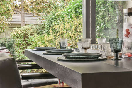 Interior of light room with stylish dining and lounge areas in modern house at daytimeの写真素材