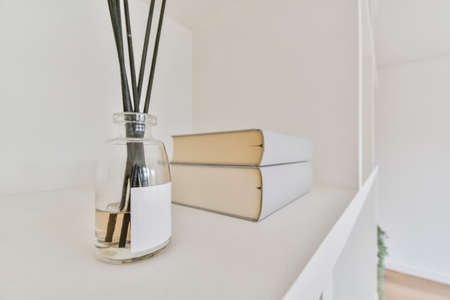 Home decor on a shelf with fragrance and a bookの写真素材