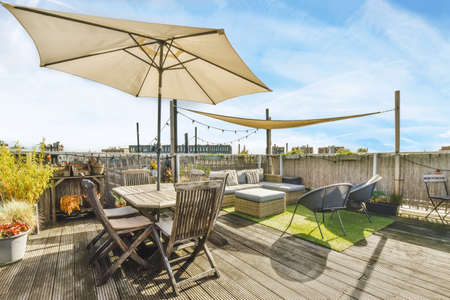 Luxurious and stylish courtyard with a garden umbrella and lots of furnitureの写真素材