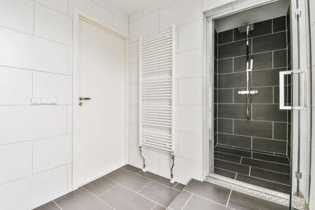 Lovely bathroom with black floor and walk-in shower, fully tiled with black tilesの写真素材