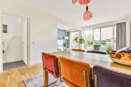 Superb dining room with a sturdy wooden table and multi-colored upholstered chairs