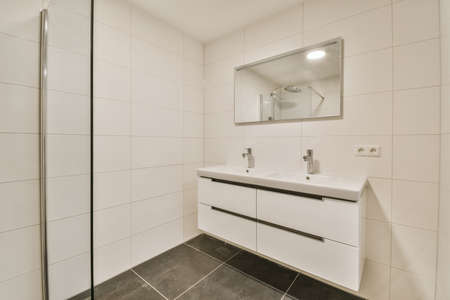 Delightful bathroom with large mirror and long sinkの写真素材