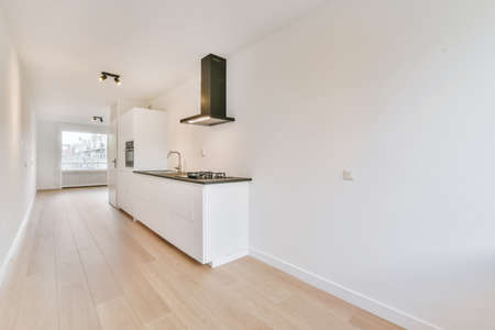 Pretty kitchen with hardwood parquet flooring and black worktopの写真素材