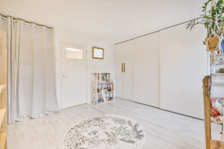 Cozy room with a large wall-to-wall wardrobe and a round rugの写真素材