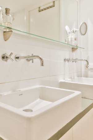 Elegant bathroom with two washbasins and a large mirrorの写真素材