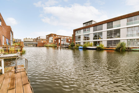 Adorable wooden boathouse in front of brick housesの写真素材