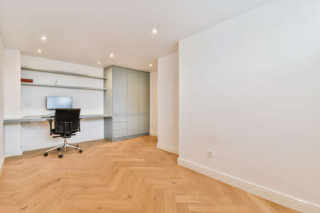Work area in a bright room with a computer and a wardrobe
