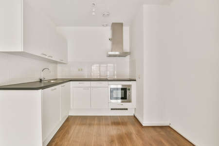 Luxurious small kitchen with white kitchen unit and delightful parquet flooring