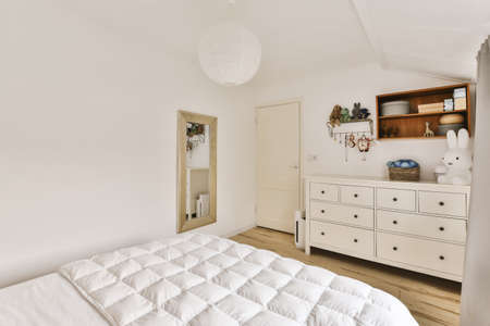 Delightful small bedroom with soft bedspread and designer chandelier