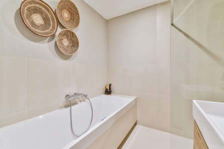 Superb bathroom in beige tones with large cozy bathtub