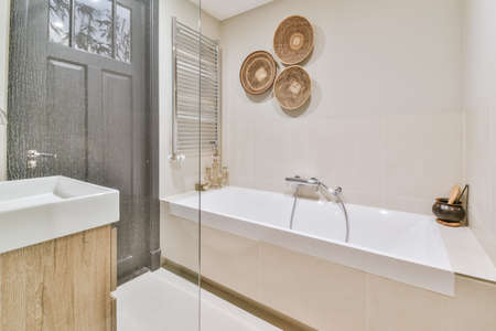 Superb bathroom in beige tones with large cozy bathtub