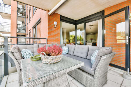 Balcony with a large wicker gray armchair with soft cushions