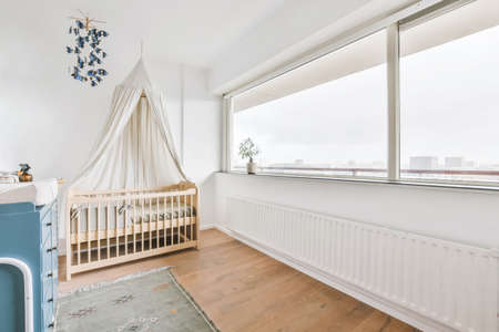 Adorable baby room with small wooden cribの写真素材