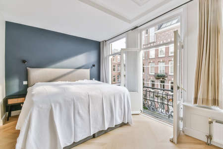 Mind-blowing bedroom with a crisp white bed and a blue wall above the bedの写真素材