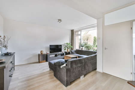 The living room interior in bright colors, gray sofa over a light parquet floor