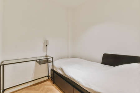 Single stylish bed in a stylish bedroomの写真素材