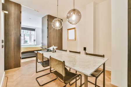 Long table in the dining room with two hanging lamps