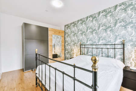 black furniture in a bright room with wallpaper on the wallsの写真素材