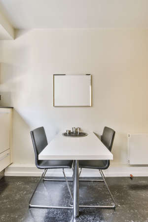 Comfortable small dining area with two chairs and a painting above the table