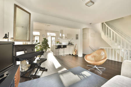 Comfortable sofa with cushions placed against light wall with decorations in modern living room