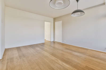 Empty large room of luxury house with wooden flooring and white walls