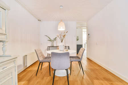 Adorable dining area with white round table and four chairs