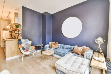 Adorable living room with low sofas and blue wall