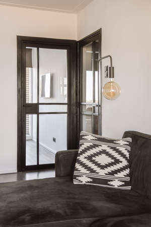 Amazing pillow on black sofa and modern lamp in the background